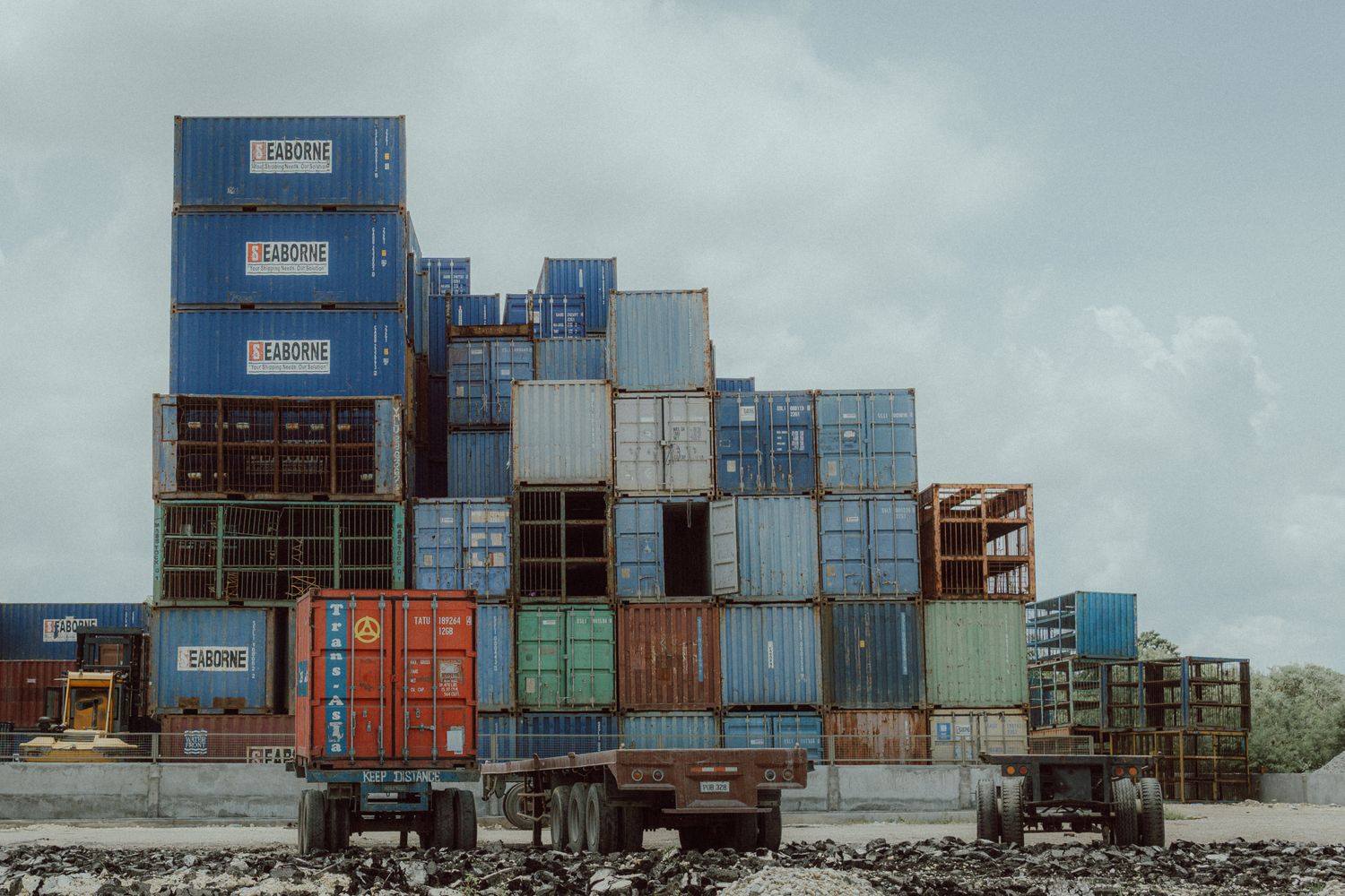 a truck is parked next to a pile of shipping containers