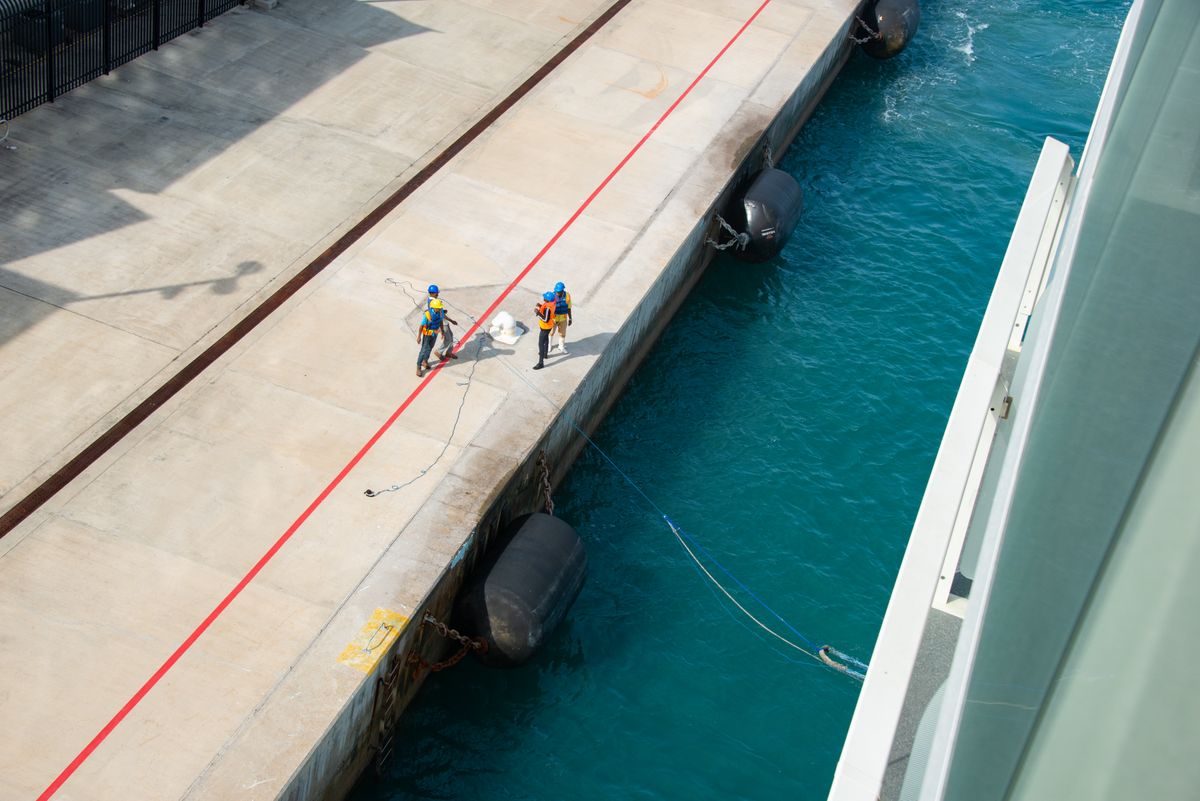 Marine workers coordinating beside a vessel