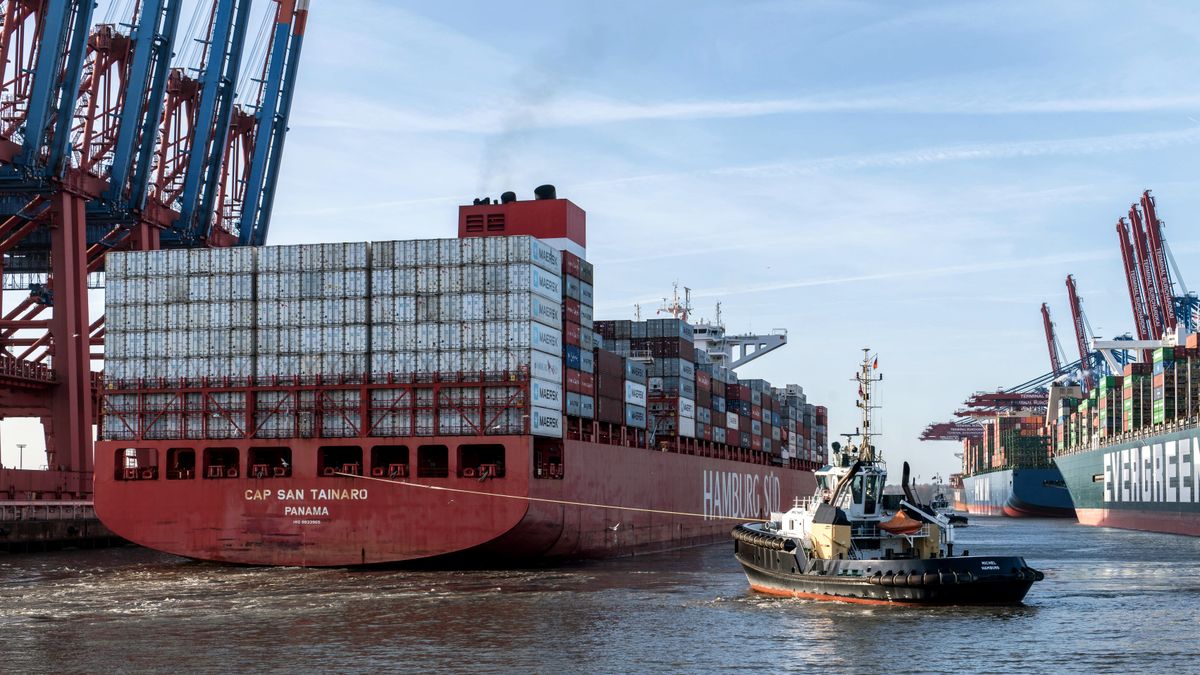 Cargo vessel and tugboat at a working container terminal